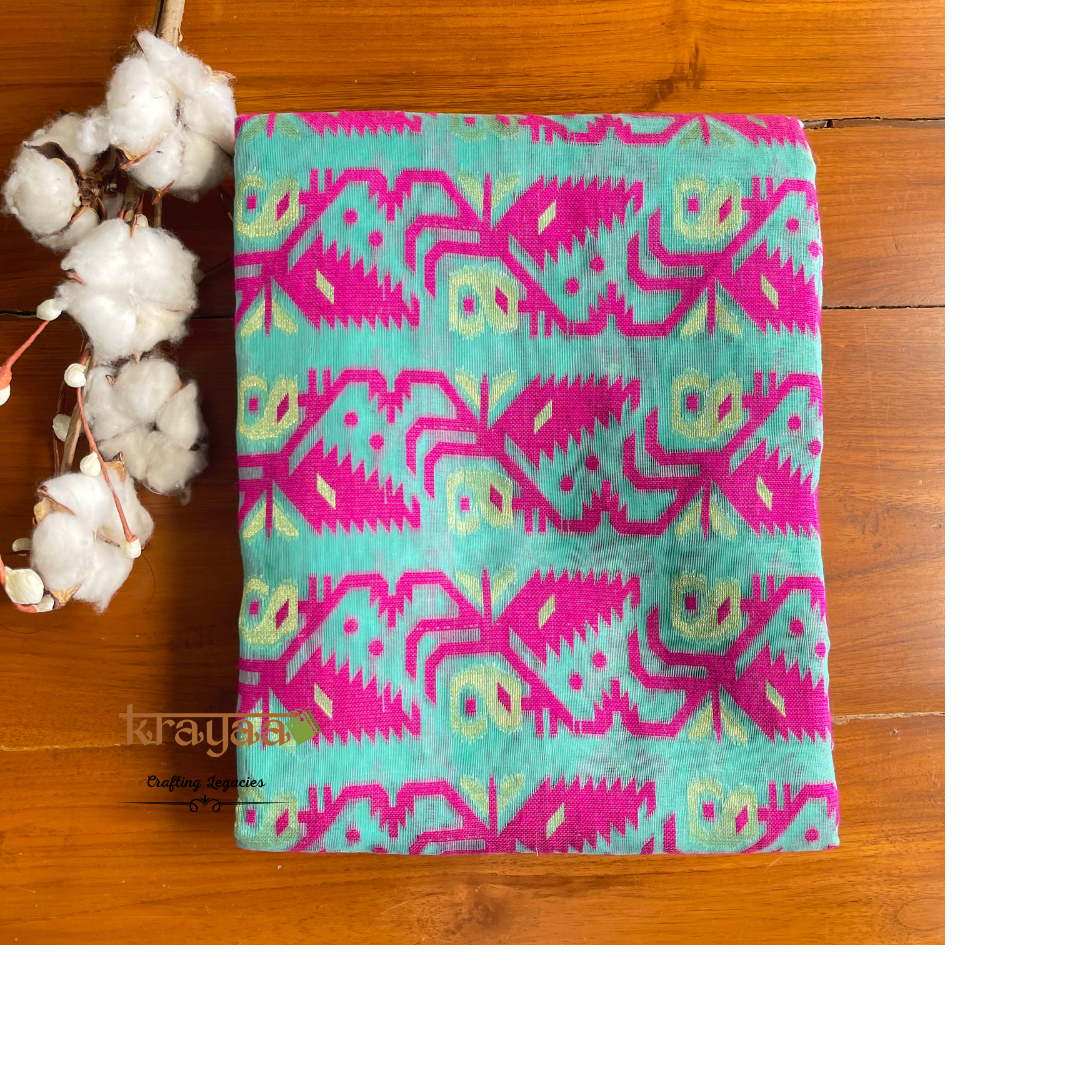 Turquoise fabric with pink and green geometric pattern on a wooden surface with cotton flowers.